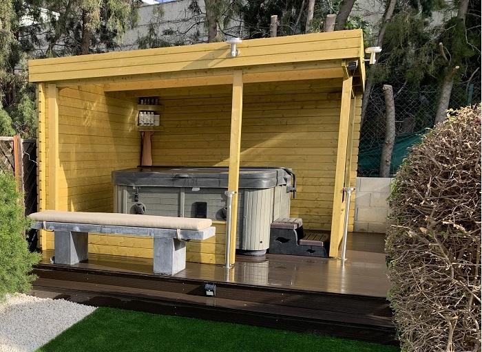 wooden gazebo with sides and a flat roof